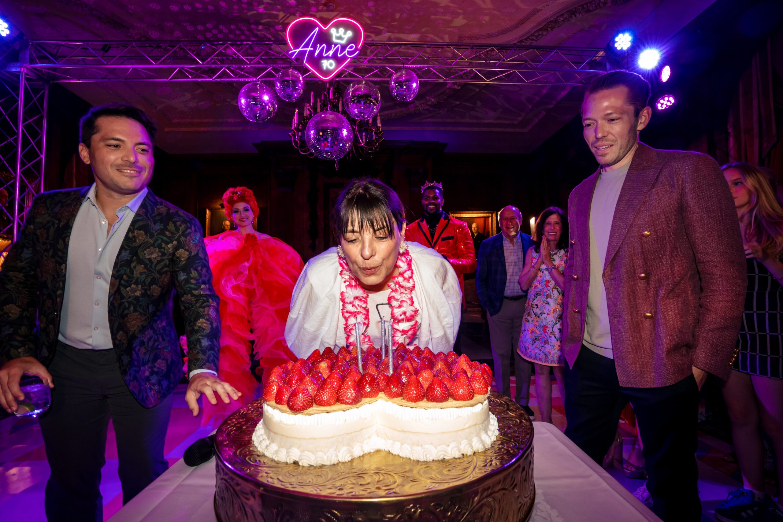 A woman leans in to blow out candles for her birthday party at Duquesne Club in Pittsburgh